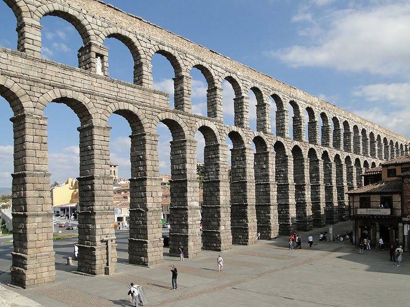 era oscuro y bajo y cerraba cuatro lados de una plaza